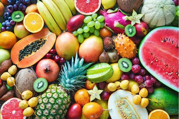 A vibrant assortment of fresh fruit including watermelon, citrus, grapes, kiwi, mango, and pineapple