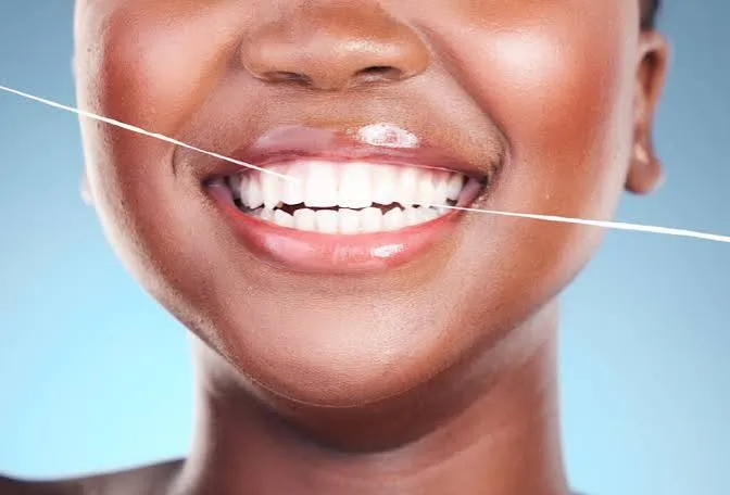 Smiling person flossing, illustrating oral health